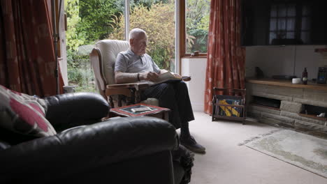 man reading a book in a living room