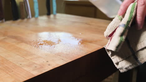 spraying solution on a wooden table to clean it - close up