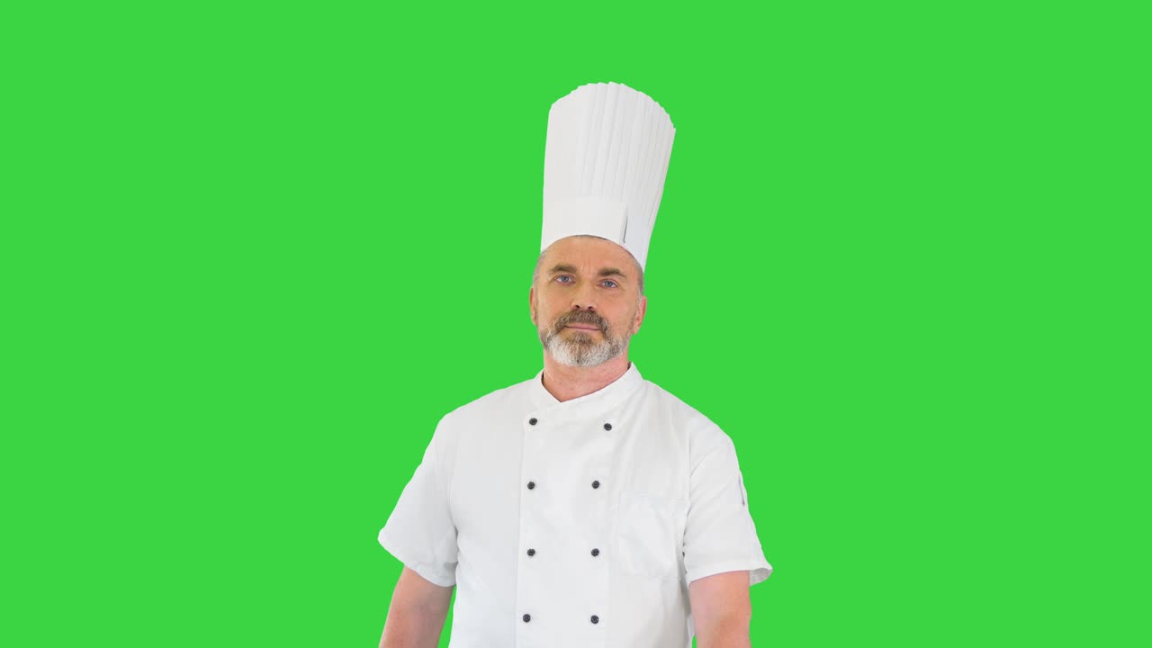 Chef in uniforme bianca che cammina su uno schermo verde, Chroma Key.
