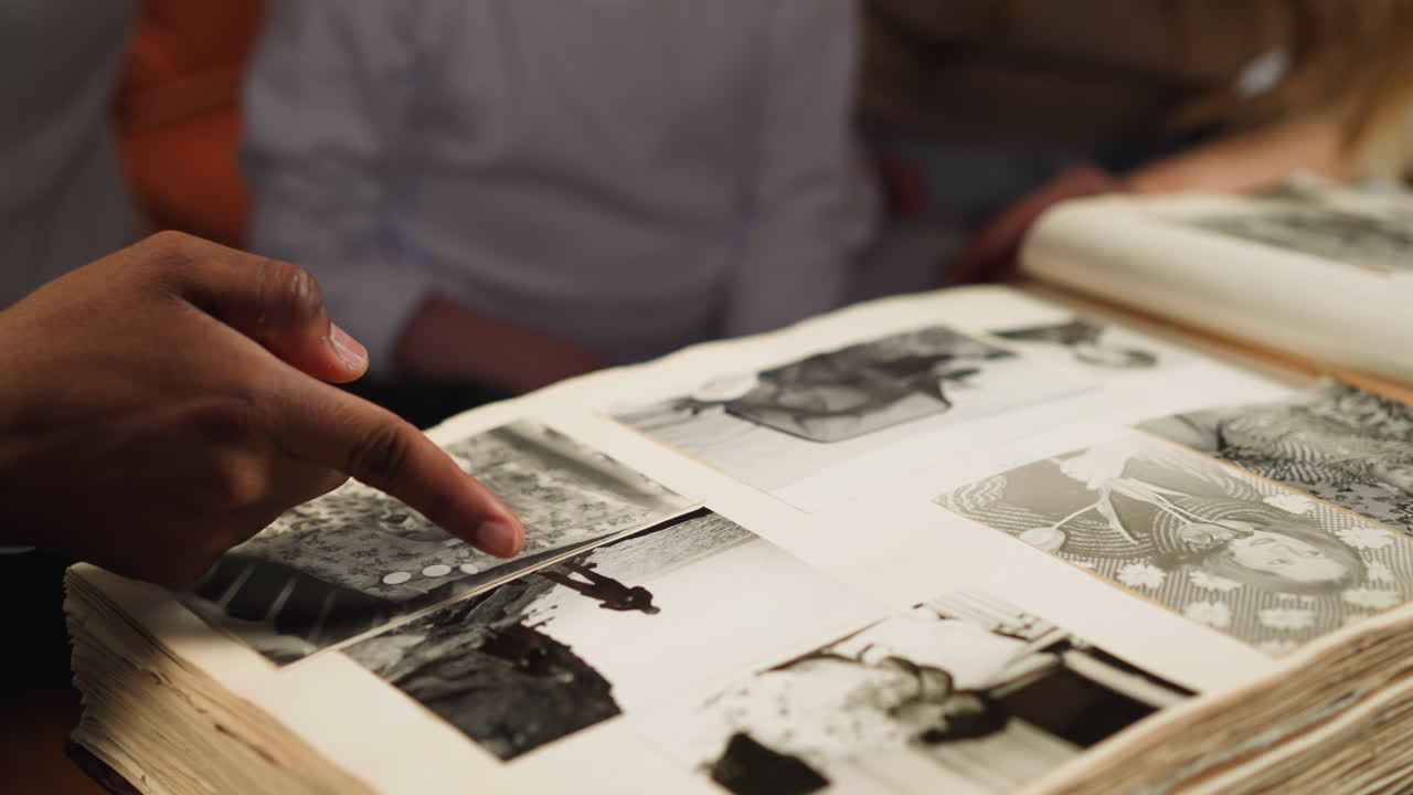 hombre negro apunta a la foto del abuelo con una niña y una mujer