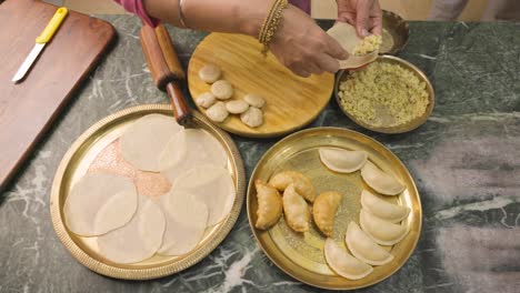 una mujer india preparando gujia, un bocadillo popular indio especialmente hecho en el festival de colores de holi