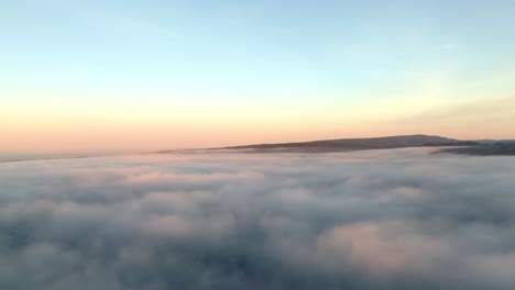 mesmerizing aerial journey as clouds glow in golden sunrise, leading toward majestic mountain