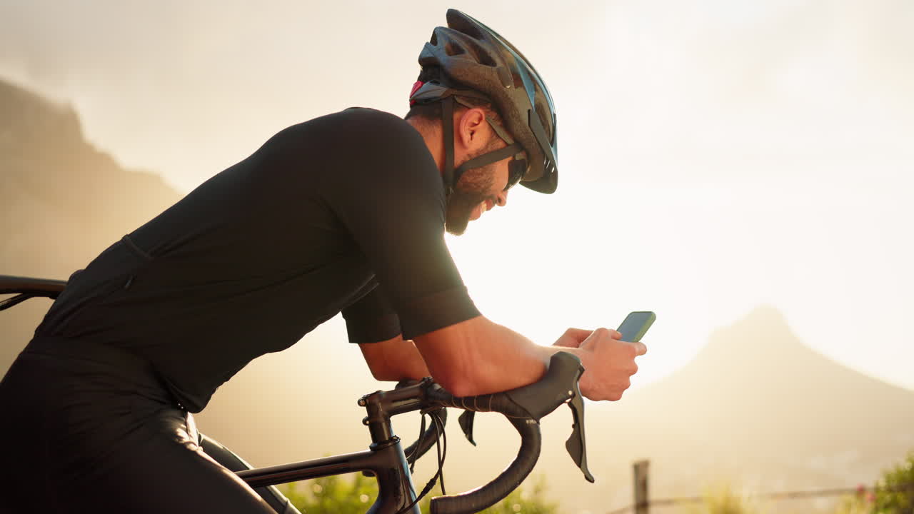 Horský cyklista s telefonem v přírodě
