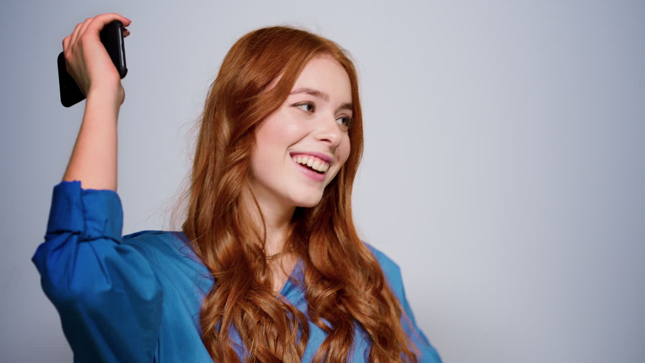 스튜디오에서 음악을 듣는 귀여운  ⁇ 은 머리 소녀. 집 안에서 전화를 들고 있는 행복한 여성