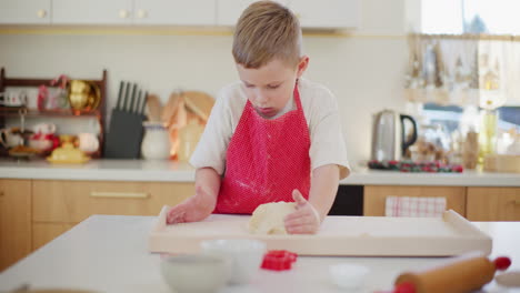 niño amassando masa de pan en la cocina