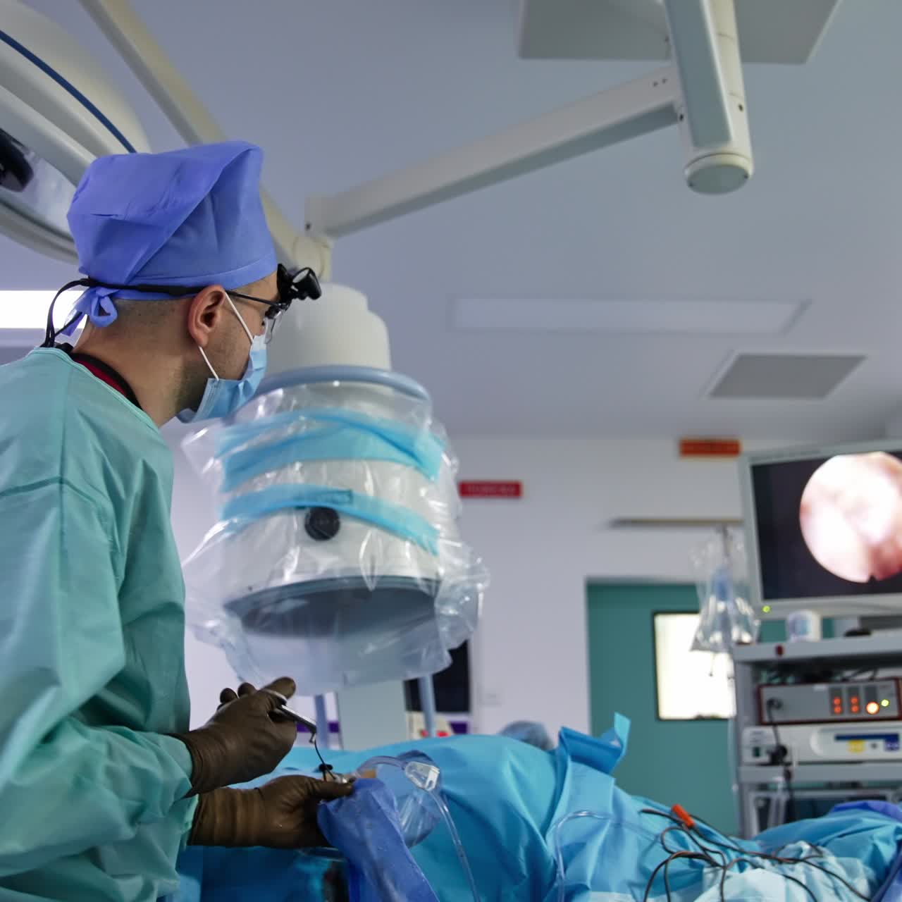 Neurosurgery professional conducting surgery with device watching the monitor. Careful moves of the surgeon at operation