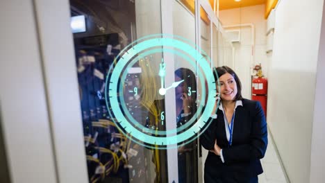 animation of clock moving fast over businesswoman with smartphone by computer servers in tech room