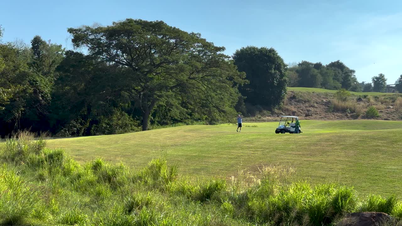 el carro de golf se mueve a través del campo de golf escénico