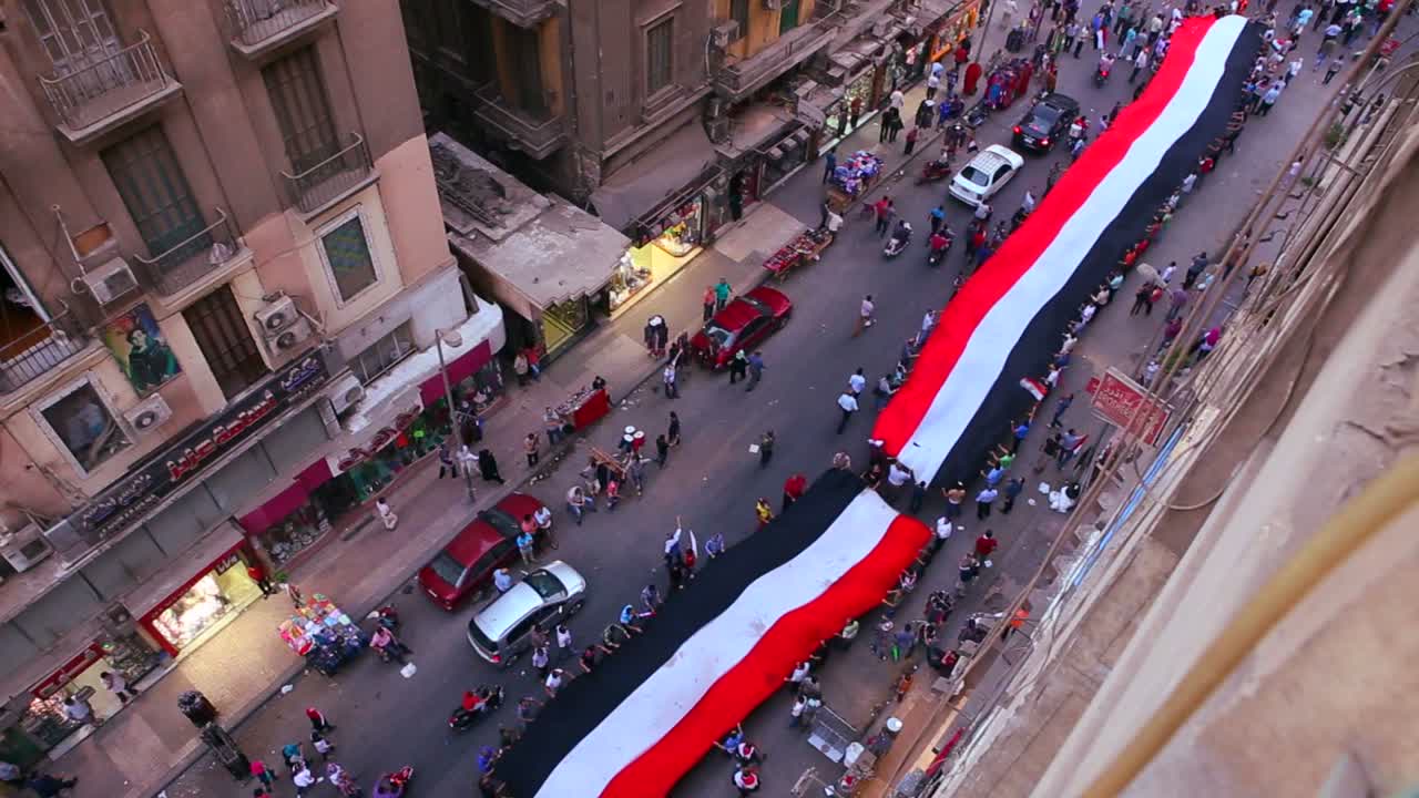 vista desde arriba mirando hacia abajo mientras los manifestantes portan pancartas marchan en las calles de el cairo egipto