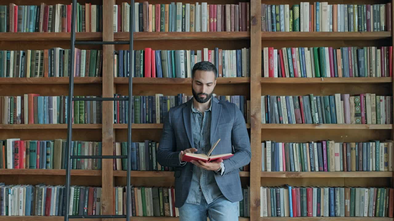 un joven en la biblioteca leyendo un libro.