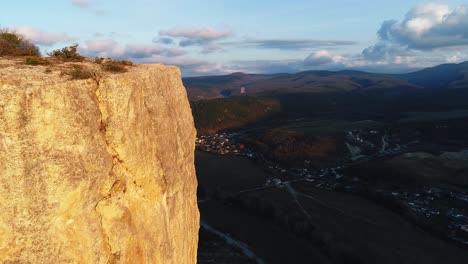 cliffside view of a valley at sunset