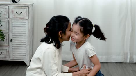 4k 25fps slow motion, an adorable asian girl sits with a single mother, the little boy shows his love for her mother with a warm kiss on the cheek and a hug. family and healthy.