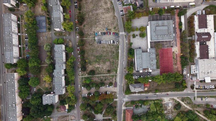 Una prospettiva aerea cattura un quartiere urbano con edifici residenziali, strade e vegetazione rigogliosa, mostrando una giornata tipica