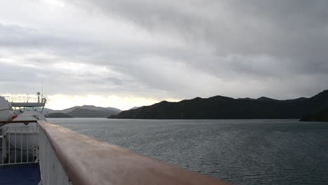 Ferry-sailing-through-the-fjords-of-Queen-Charlotte-Sound,-New-Zealand-on-a-calm,-overcast-evening