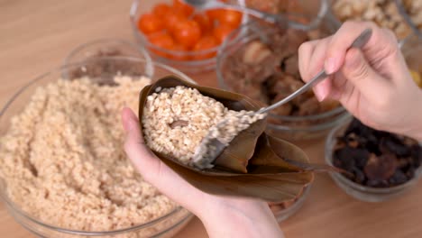 hacer comida zongzi - preparar y envolver dumplings de arroz chinos.