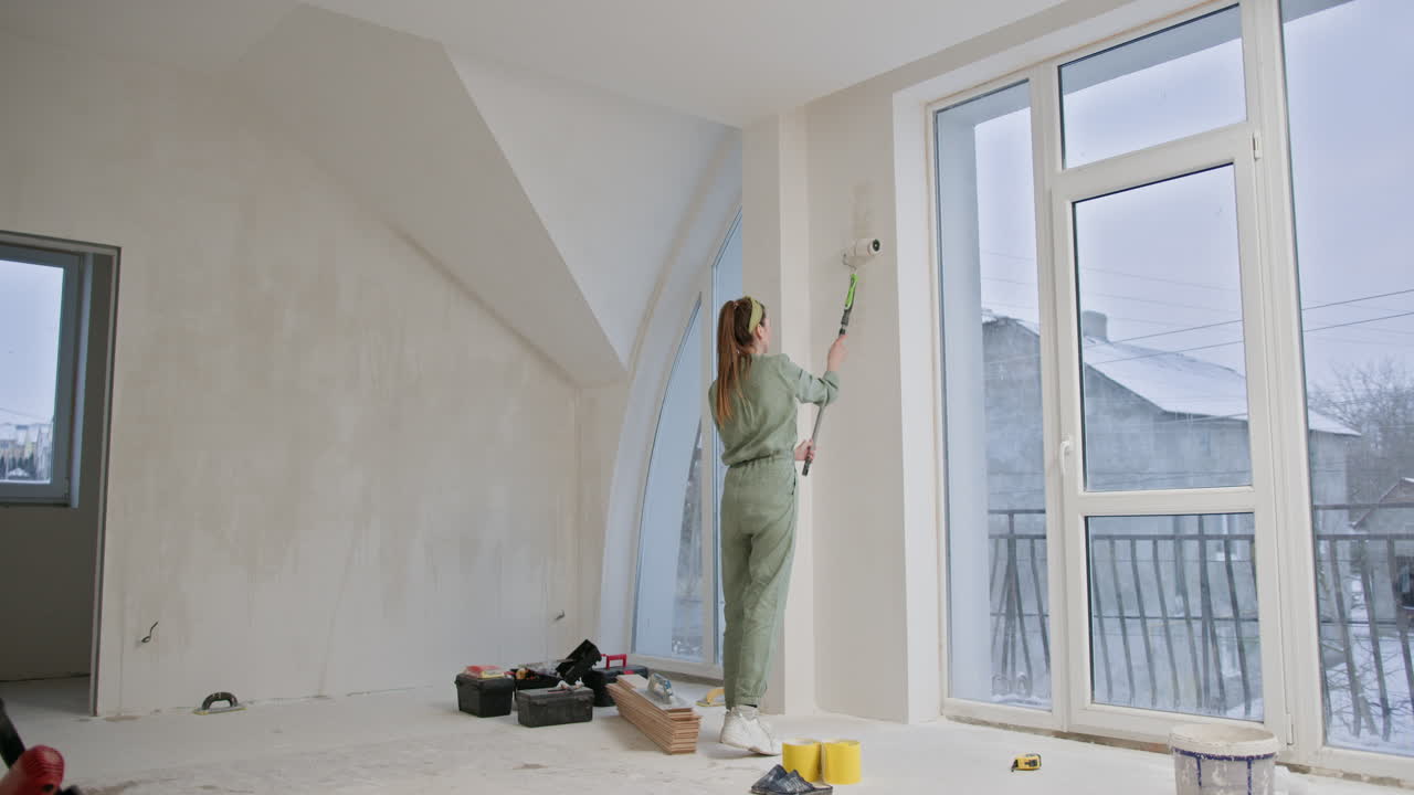 mujer pintando paredes en un nuevo apartamento
