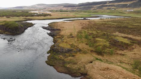 aerial footage over a river going towards glanni waterfall in iceland