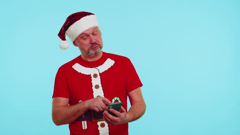 Mann-Mit-Weihnachts-T-Shirt-Und-Hut-Tippt-Mit-Seinem-Mobiltelefon-Einen-Neuen-Beitrag-Im-Internet-Ein,-Kauft-Online-Ein-Und-Stöbert