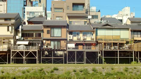 slide shot of houses lined up along a river in kyoto, japan 4k slow motion