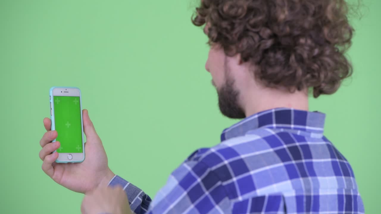 Young handsome bearded hipster man with curly hair