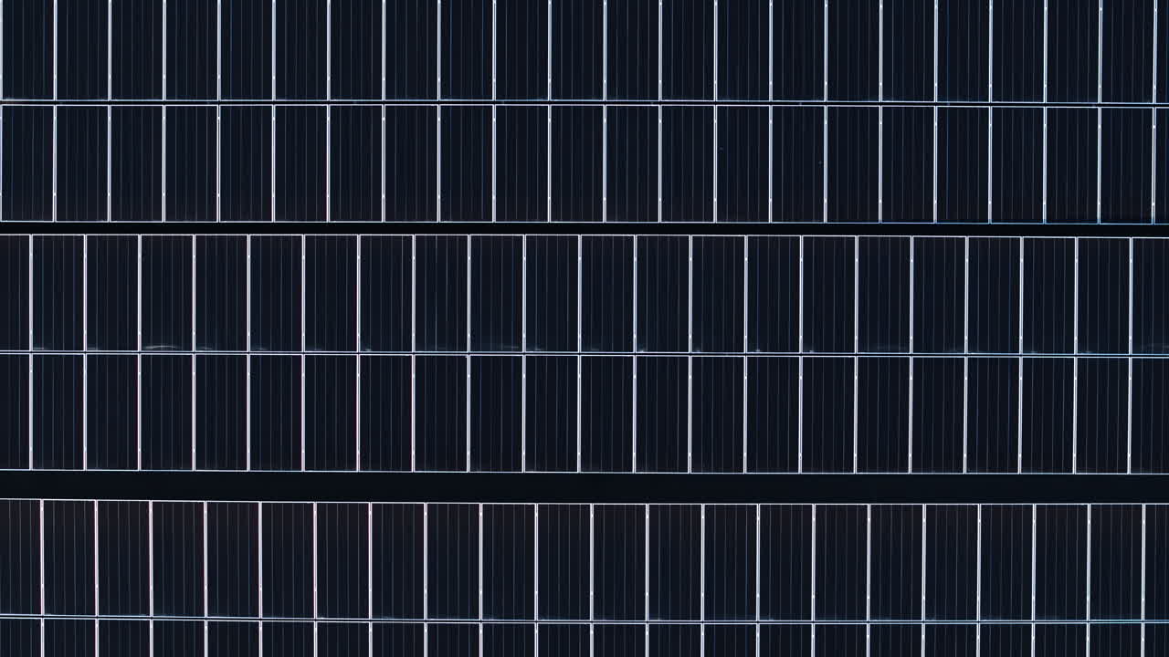 Aerial drone view of solar panels at sunset. Photovoltaics on top of the roof of the building. Alternative electricity source. Concept of sustainable resources