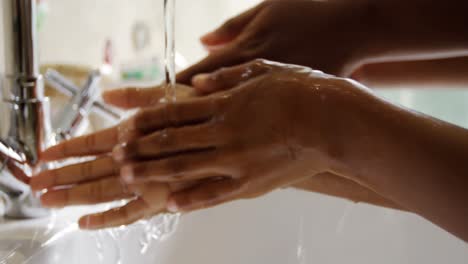 madre e hija lavando las manos en el fregadero del baño 4k