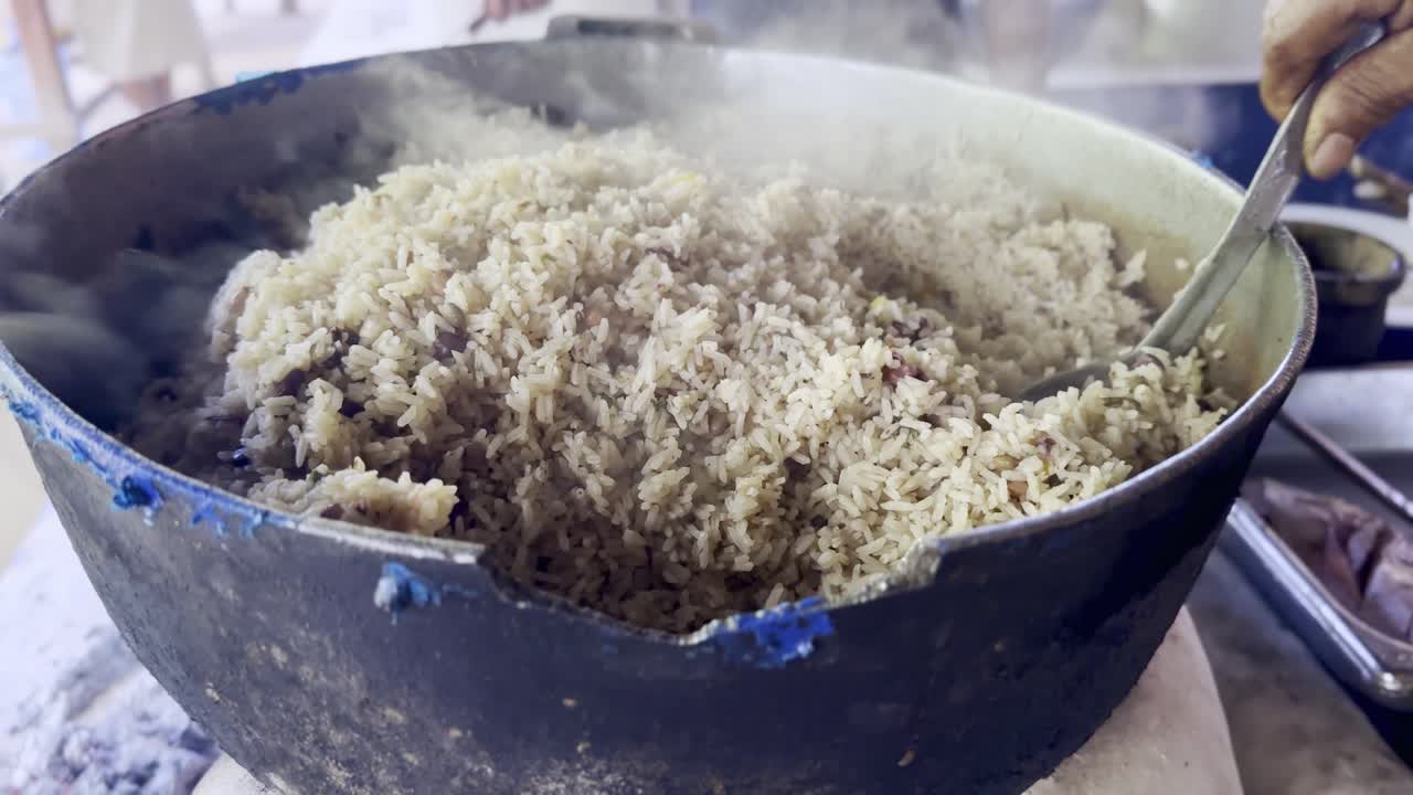 cocinar a mano y poner en el plato moro de guandules comida típica de la república dominicana