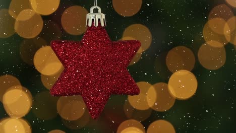 Animation-of-snow-falling-over-red-star-christmas-bauble-decoration