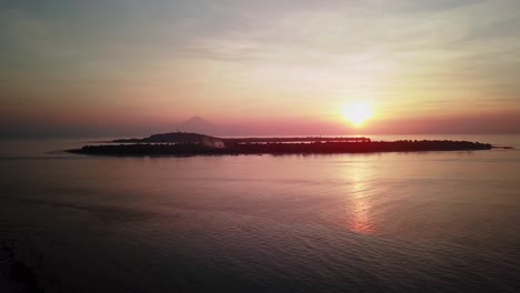 sunset view of a volcano from a tropical beach