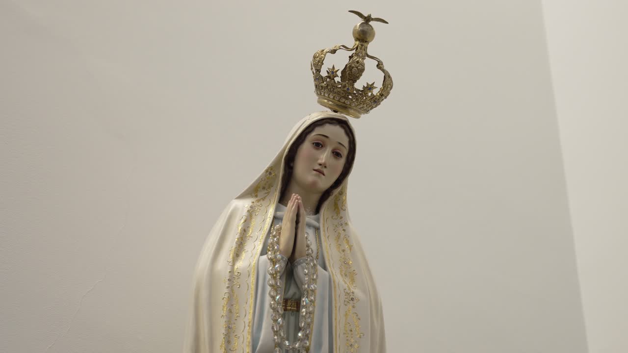Close up of a serene Virgin Mary statue with crown, in a peaceful, minimalist setting