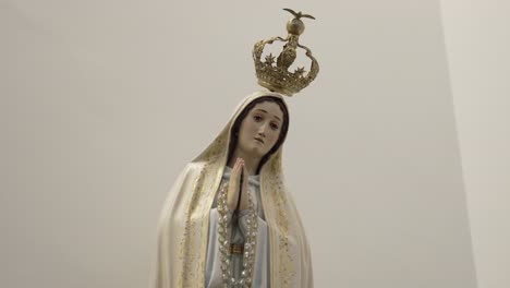 close up of a serene virgin mary statue with crown, in a peaceful, minimalist setting