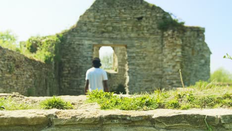 imágenes en 4k de un hombre negro saliendo de las ruinas de una antigua iglesia en inglaterra
