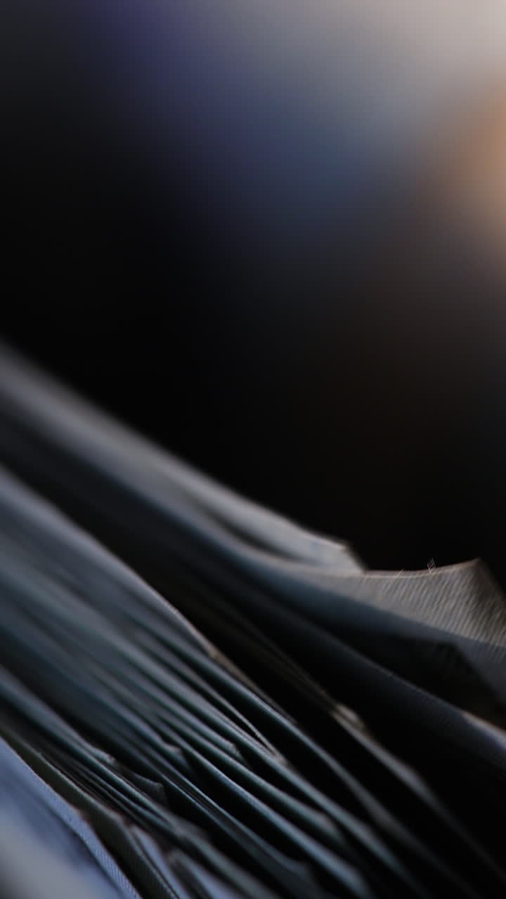 American one hundred dollar bills are counted in the machine. Macro footage of banknotes moving in equipment. Close up. Vertical video