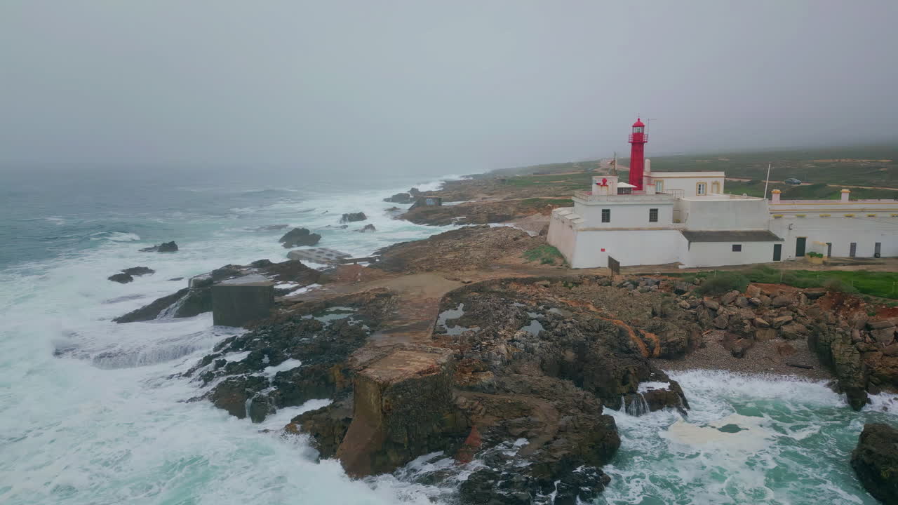 Lonely lighthouse standing stormy sea shore under grey sky. Marine landscape