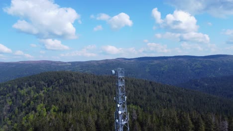 aerial orbit view around a 5g telecom antenna mast pylon among mountain forest in sérichamp vosges france 4k