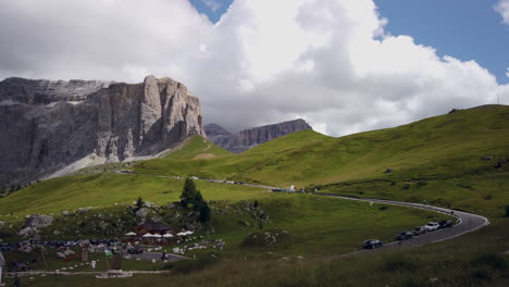 view from sassolungo - langkofel as cars go over the sella pass in the italian dolomites