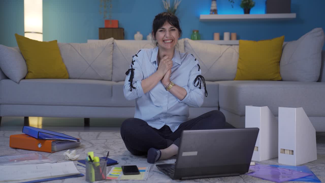 가정 사무실 직원 여성이 카메라를 바라보고 박수를 치고 흥분하고 있습니다.