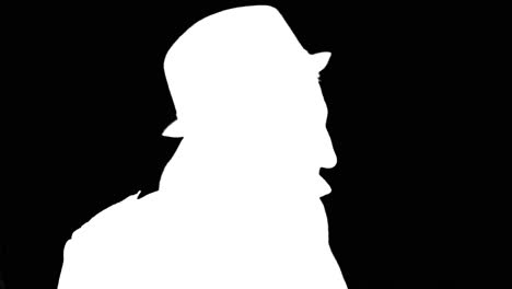 mysterious man in coat and hat turning around, white silhouette on black background