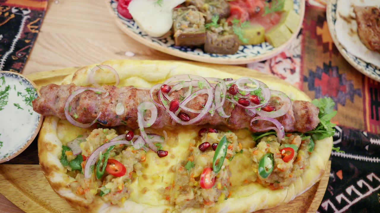 Carne macinata grigliata servita su pane piatto con verdure ed erbe aromatiche
