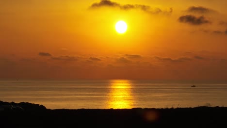 impresionante cielo naranja con un amanecer sobre el puerto natural de sa nitja, menorca