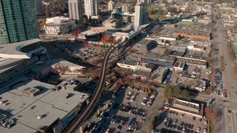 drone 4k footage above surrey cityscape with highrise buildings train track roads and parking lots with traffic congestion and pollution