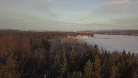 Frozen-lake-in-Falun,-Sweden-during-a-cold-winter-in-December,-filmed-with-a-drone