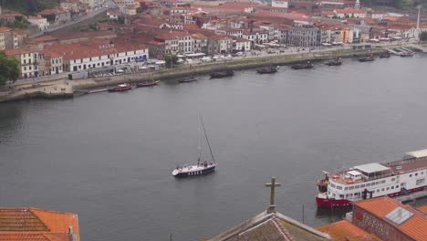 Ein-Panoramablick-Auf-Ein-Boot,-Das-An-Einem-Bewölkten-Tag-Am-Fluss-Douro-In-Porto,-Portugal,-Vorbeifährt