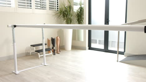 prosthetic legs displayed in lab with parallel bars for rehabilitation therapy