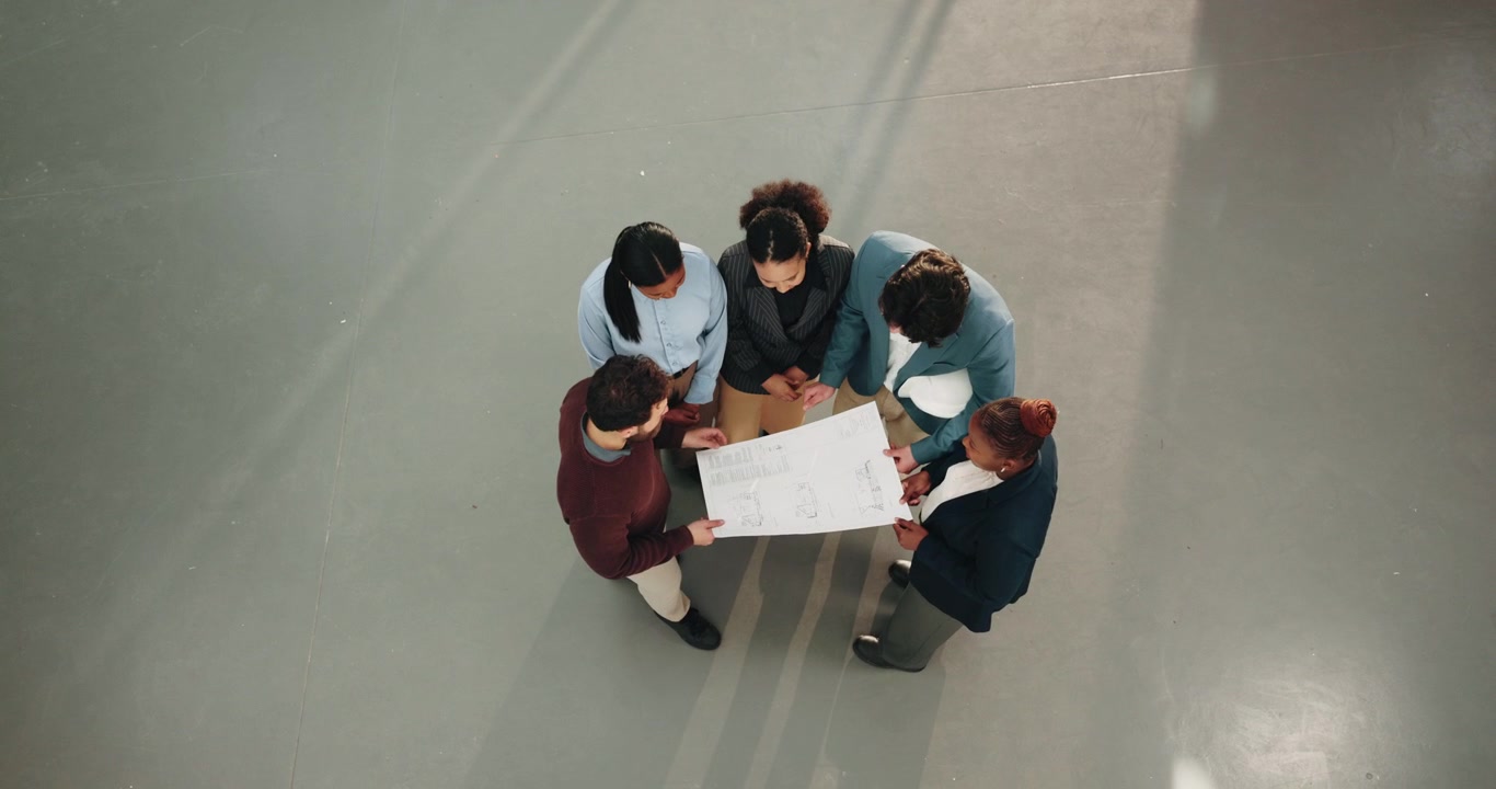 Team eterogeneo di architetti che esamina progetti in un ufficio moderno