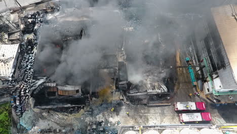 aerial view overlooking firefighters extinguishing a house on fire, sunny day, in port-au-prince, haiti - tracking, drone shot