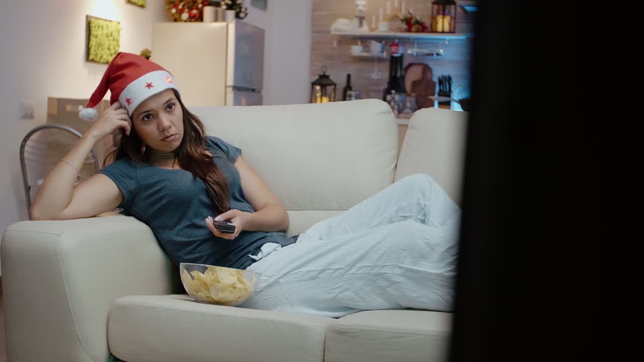 Adulto entediado segurando o controle remoto da TV e mudando de canais