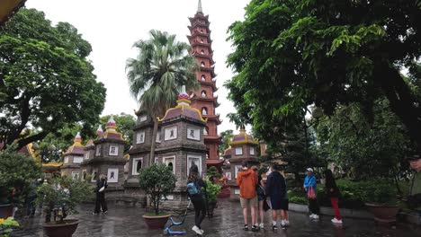 visitantes explorando la pagoda bajo la lluvia