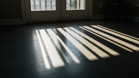 natural light streaming through the windows casts beautiful shadows on the floor, creating a serene atmosphere in the empty room