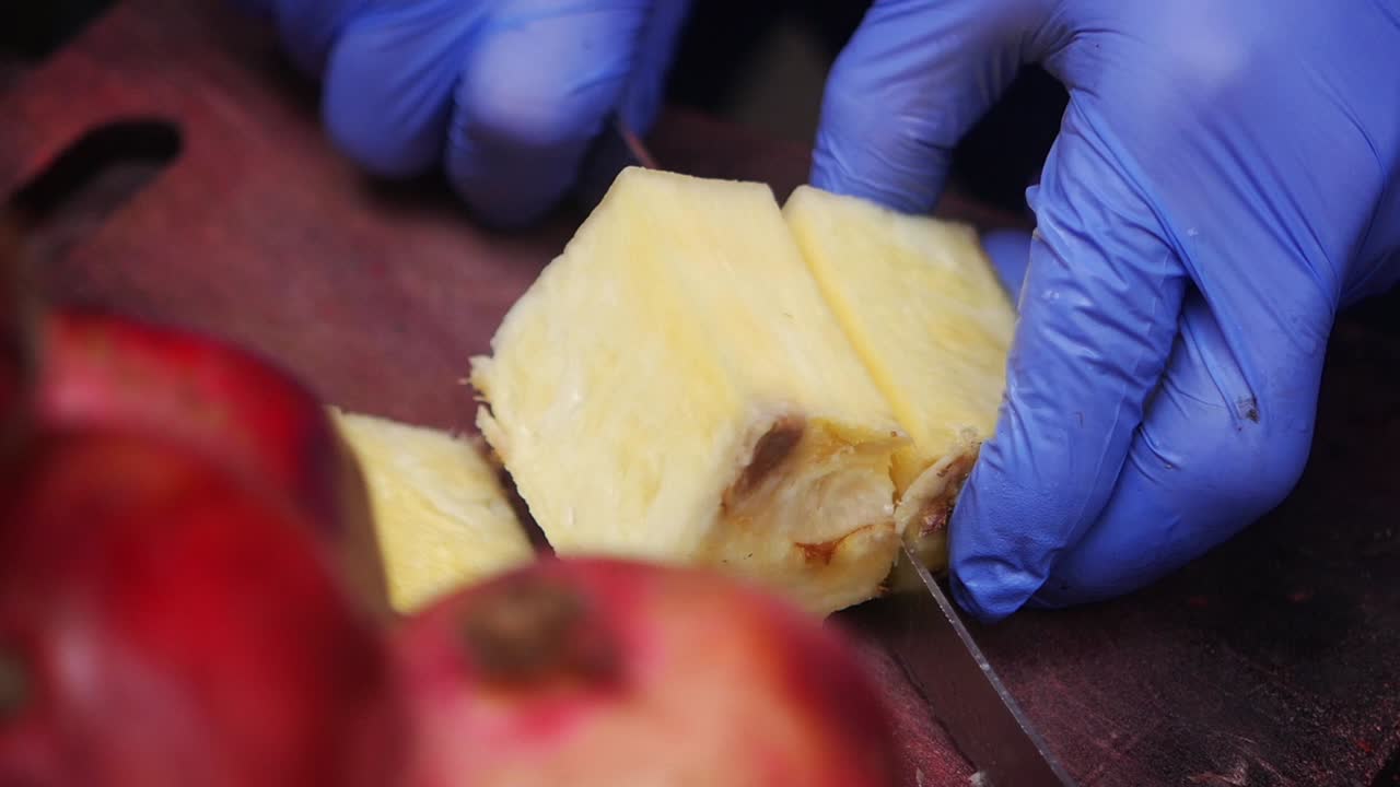 Cutting Pineapple with Blue Gloves